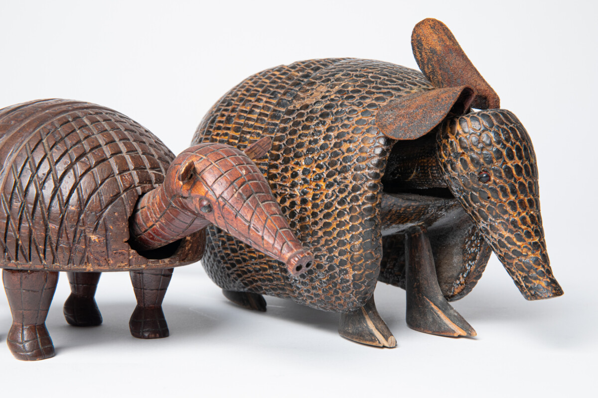 Two armadillo sculptures from Brazil. One made from a coconut shell, and the other carved from wood. 1993-55-035 and 1995-37-001.
