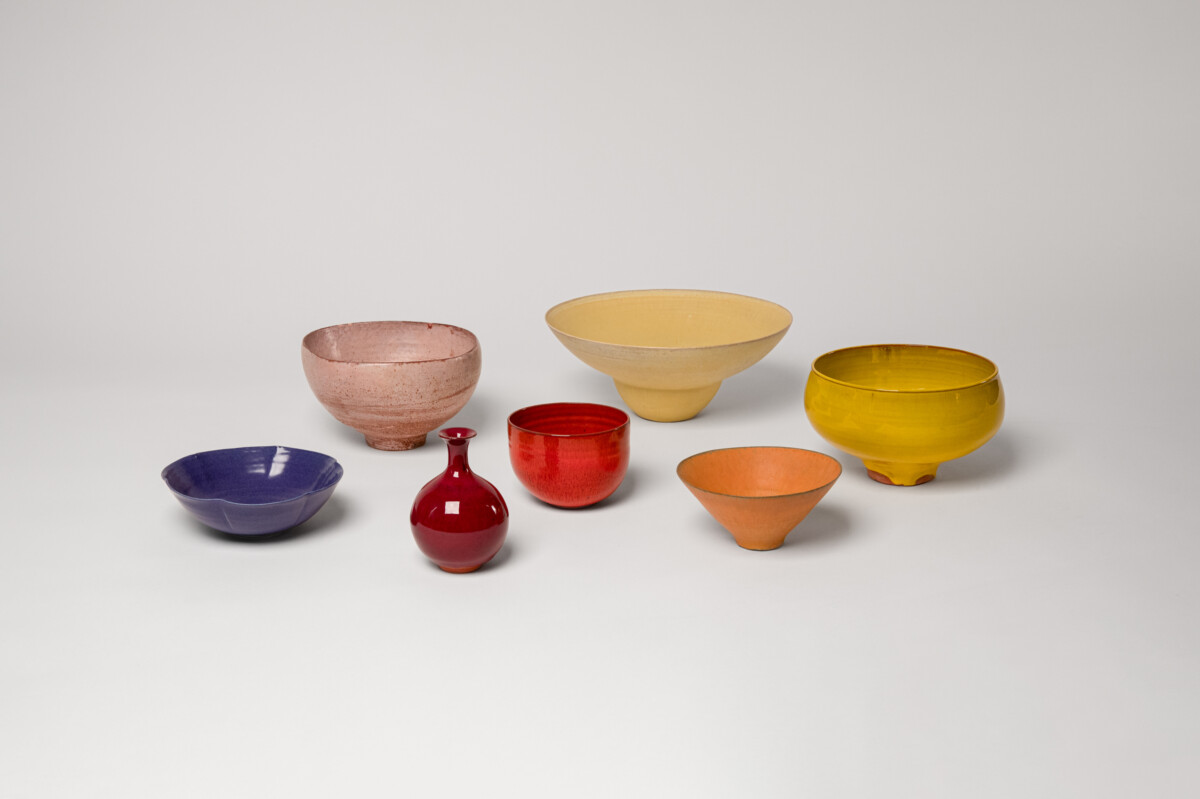 A collection of ceramic vessels in blue and shades of warm tones, reflecting a sunset made by Laura Andreson.