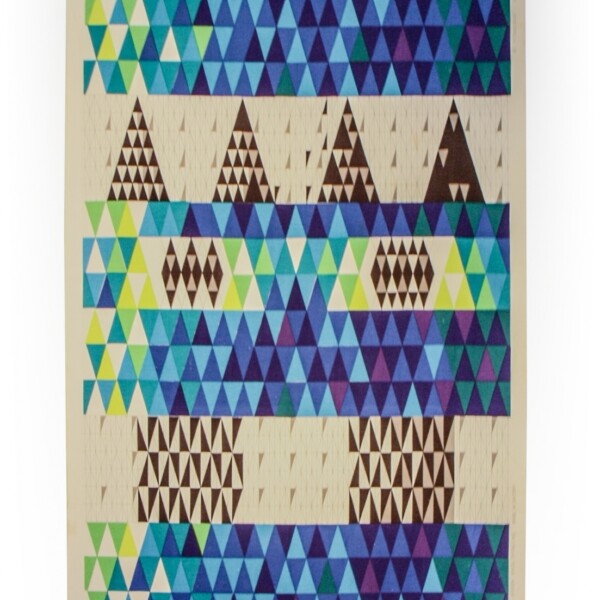This textile is a woven and printed cotton drapery fabric. It includes repeating bands of small triangles in brown, shades of blue, shades of green, yellow, and white.