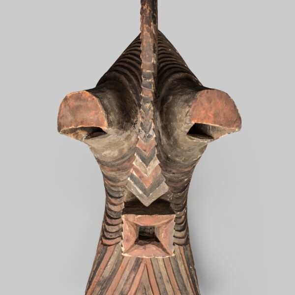 This wooden kifwebe, or mask, has a face that is boldly simplified with a high protruding forehead, close-set eyes under hooded eyelids, and is completely covered by a dense network of painted parallel grooves.