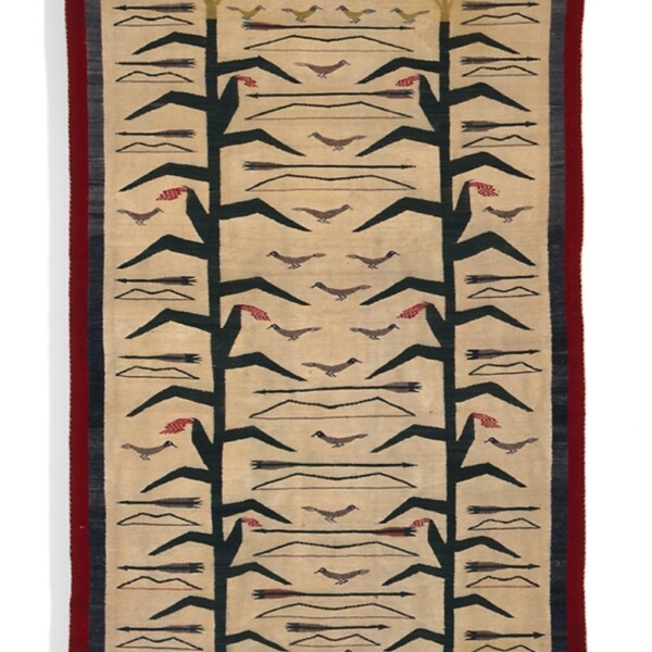 This Navajo rug is a weft tapestry woven of handspun wool. It depicts two stalks of corn with birds flying around the tops.