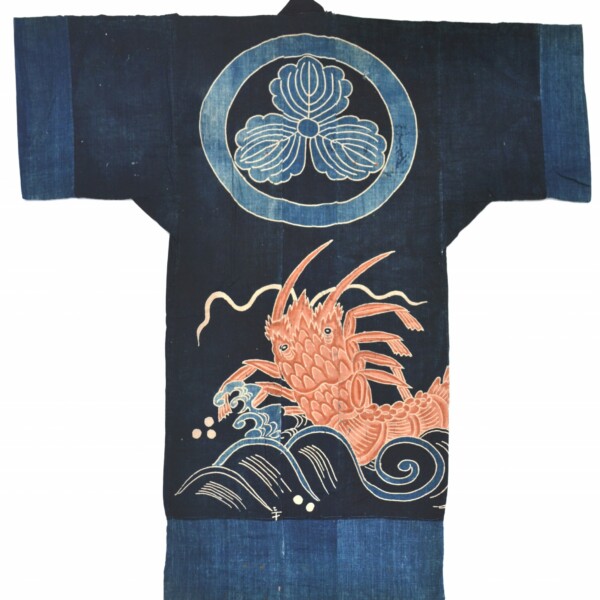 This sleeping garment (yogi) includes a lobster rising above a wave design on indigo dyed cloth. Above the lobster and wave is a circle outlining a triangular floral design.