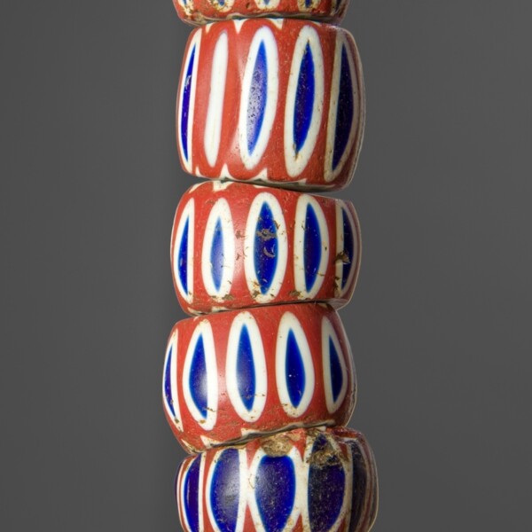 This bead strand is made of  varying size, shape, color and form. These beads have a terracotta colored base with blue ovals outlined with white encircling the bead.