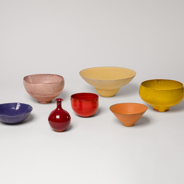 A collection of ceramic vessels in blue and shades of warm tones, reflecting a sunset made by Laura Andreson.